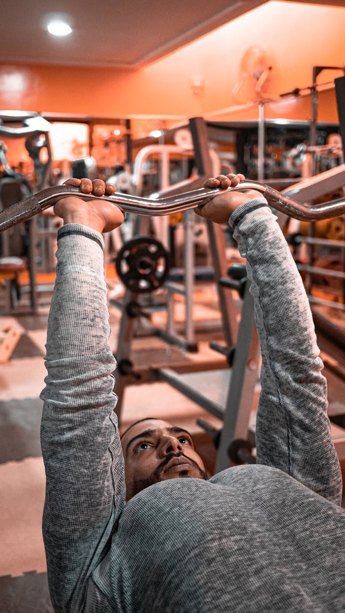 Man engaged in weightlifting exercise in a Moroccan gym setting.